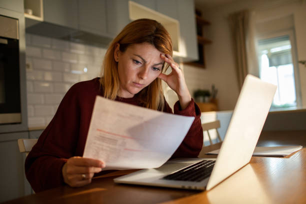 istock Young woman going over her finances at home while using her laptop 1504023190