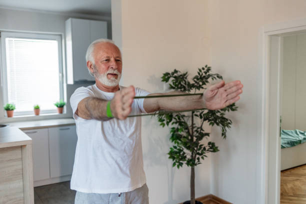 istock Senior man exercises with resistance band at home. 1504039443