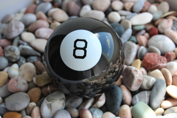 istock Black Billiard Ball Number Eight Lying On A Colored Smooth Pebbles Top View 1504040441