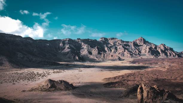 istock Expansive desert mountain range with dirt ground and rocky terrain. 1504055948
