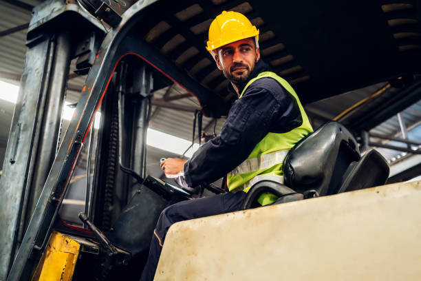 istock Man worker at forklift driver happy working in industry factory logistic ship. Man forklift driver in warehouse area. Forklift driver sitting in vehicle in warehouse 1504070368