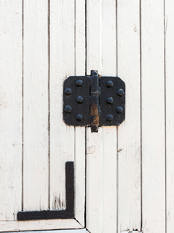 vintage black door hinges on a white fence