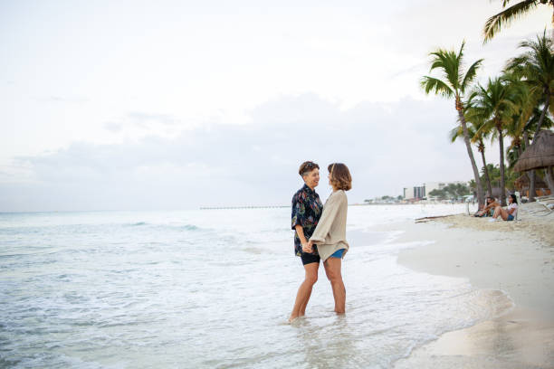 Beautiful Latin brunette walks along the beach while carrying her laptop and communication equipment in her bag to continue working while resting