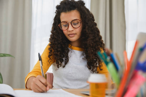 istock Student sitting at her desk with pills infront of her 1504092751