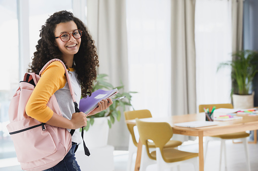 Portrait of a female student standing infront of her classroom