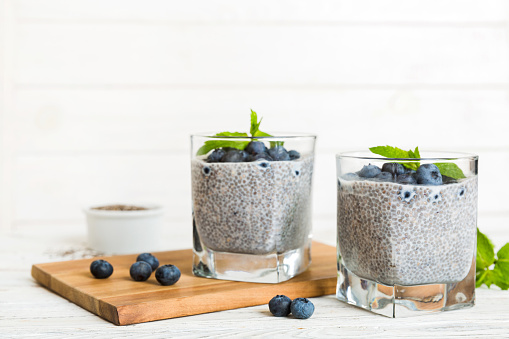 Healthy breakfast or morning with chia seeds vanilla pudding and blueberry berries on table background, vegetarian food, diet and health concept. Chia pudding with coconut milk and blueberry.