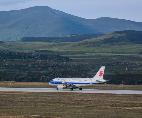Daocheng, China - Aug 15, 2016. An Airbus A319 airplane of Air China taxiing on mountainous runway at Daocheng Yading Airport (DCY).