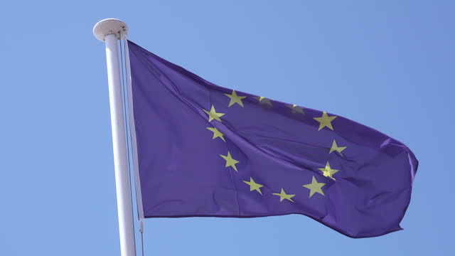 European Union (EU) flag waving in the wind on a flagpole