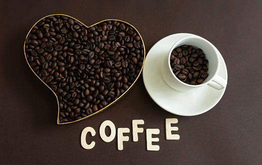 White cup with coffee beans and heart