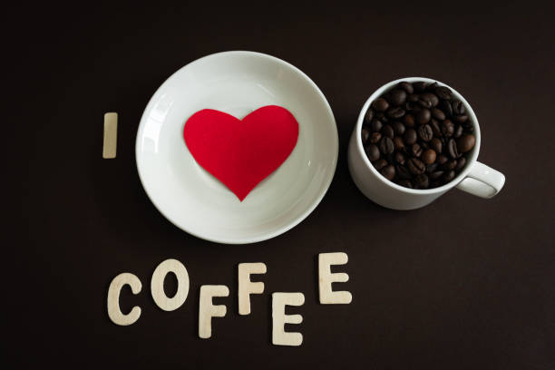 I Love Coffee concept background design flat lay image of coffee beans in a white cup with red heart shape