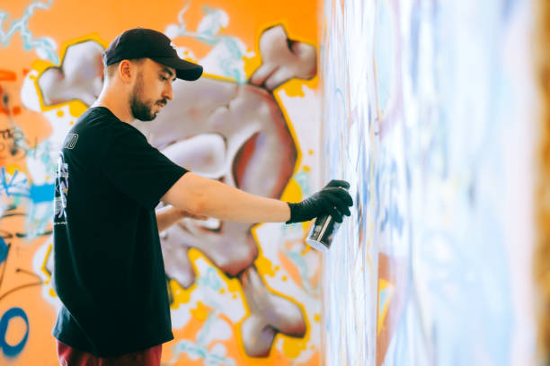 istock Young caucasian man graffiti artist drawing on a wall. 1504131206