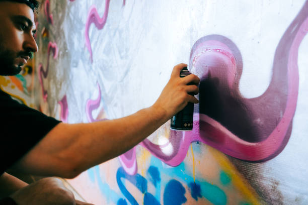 istock Young caucasian man graffiti artist drawing on a wall. 1504131397