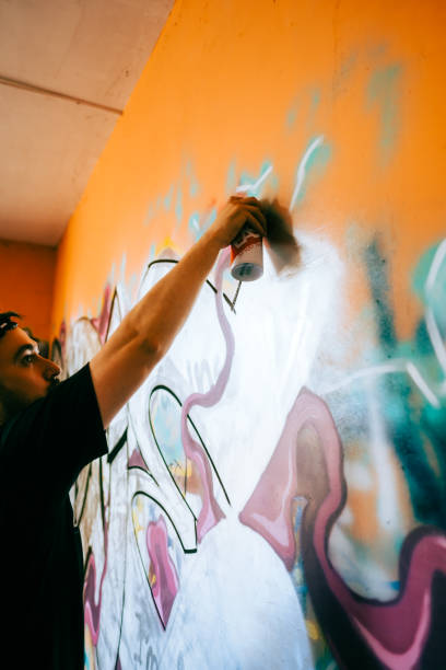 istock Young caucasian man graffiti artist drawing on a wall. 1504132203