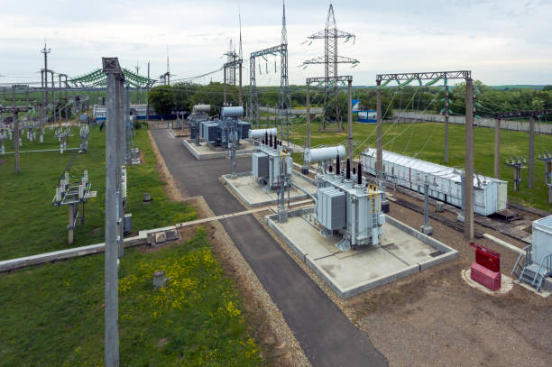 Top view of a high-voltage distribution substation. At the substation site, many insulating poles, busbars and switches are visible, which are visible from the elevation. transformador de potencia en estación de distribución de alta tensión en subestación eléctrica moderna, subestación eléctrica industrial vista superior, vista superior de transformadores, interruptores, aisladores y barras colectoras de la subestaci