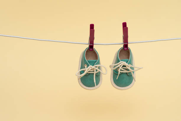 istock Children's sneakers hanging on a clothesline. Newborn concept 1504154036