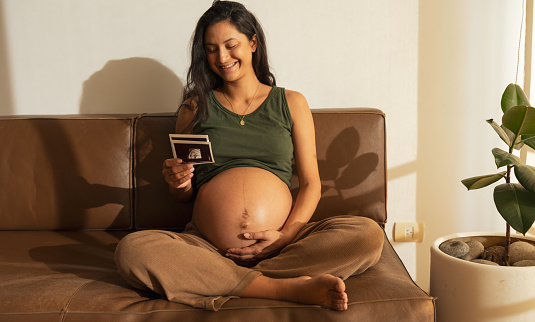 Point of view, Latin woman looking at ultrasound scan at home
