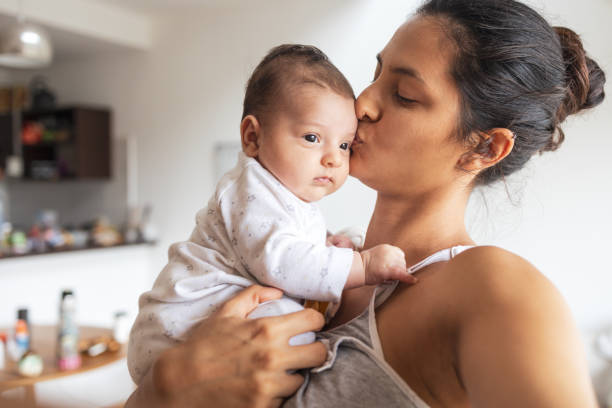 мать и ребенок дома - baby kissing mother lifestyles стоковые фото и изображения