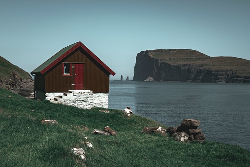 A Breathtaking view of a traditional village situated on the Faroe Islands surrounded by a stunning blue sky
