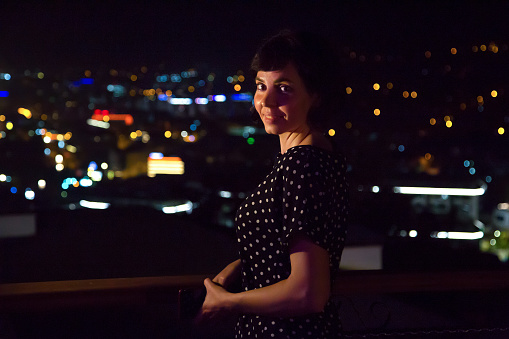 Portrait of a woman against the backdrop of the lights of a big city.