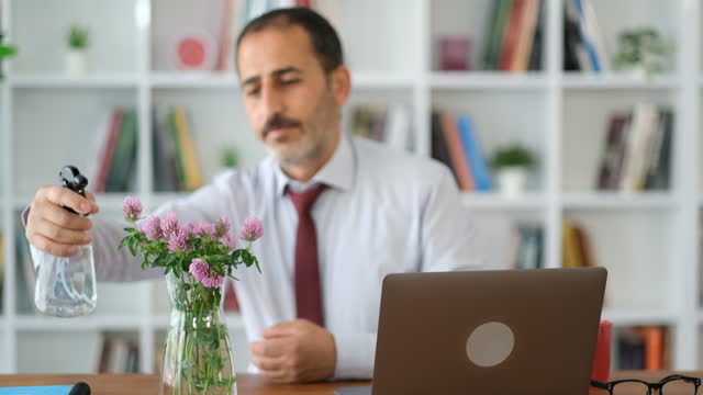 placing flowers in vase on desktop