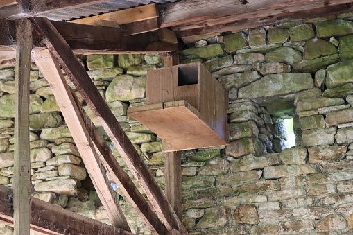 Owl box high up on a stone barn wall