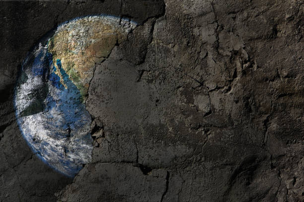 istock Faded, peeling Planet Earth on a scratched, discolored concrete wall, with copy space 1504177064