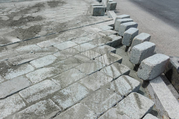 istock Construction installing and arranging precast concrete pavers stone for road at the construction site. 1504200512