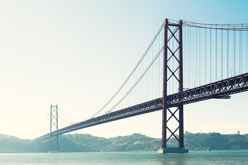 25th April Bridge in Lisbon, Portugal. Summer seascape at sunrise.. Famous travel destination