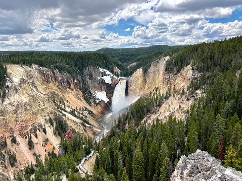 View of Lower Falls and the yellow canyon walls.\nThe Yellowstone River has carved down more than 1,000 feet to create the Grand Canyon of the Yellowstone