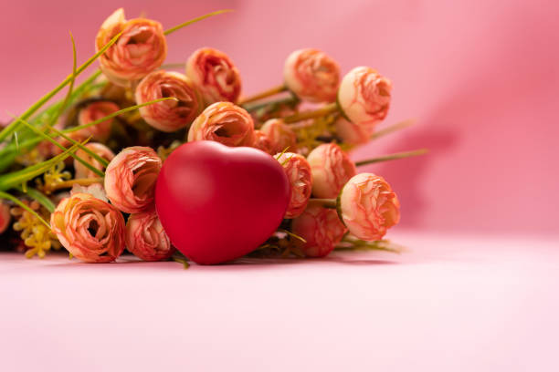 Red heart shape with flowers isolated on light pink colour background