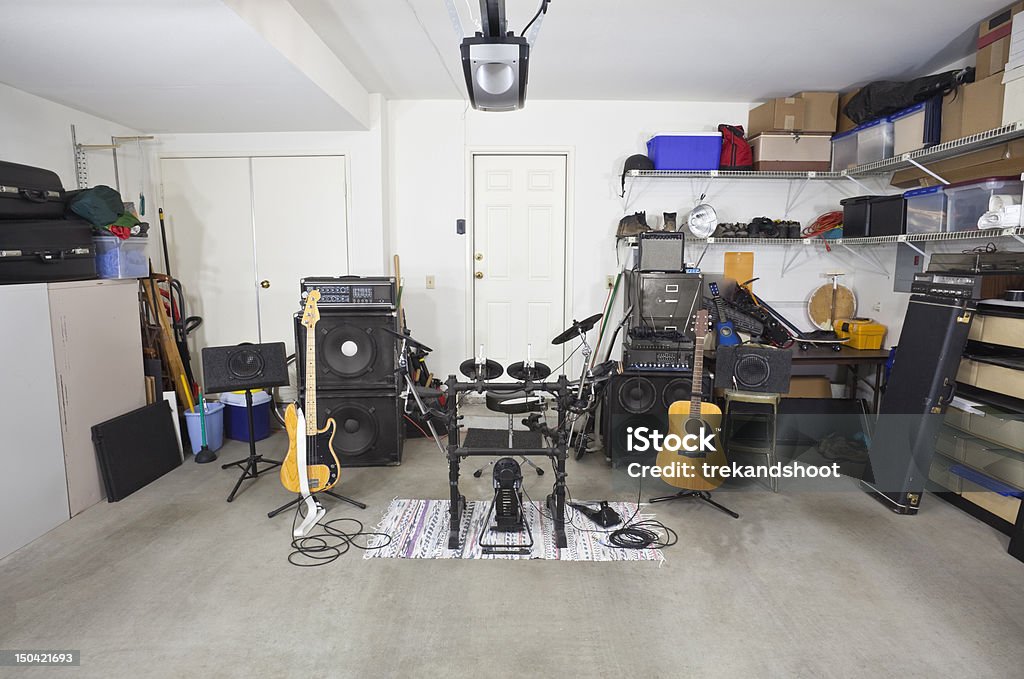 Rock band music equipment in cluttered garage Rock band music equipment in a cluttered suburban garage. Garage Stock Photo