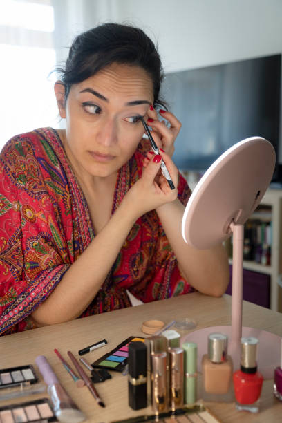 istock beautiful young woman applying eyeshadow with brush 1504221221