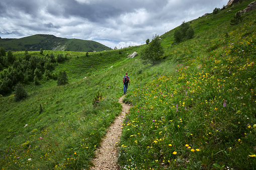man hiking in the mountains with backpack on trails