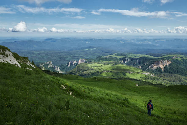 man hiking in the mountains with backpack on trails