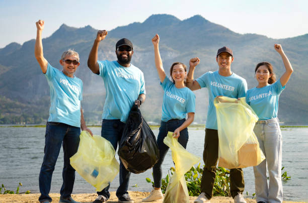 istock volunteers doing hands up together for powerful volunteering charity,a diverse group of volunteers join together to cleanup the sand beach 1504227654