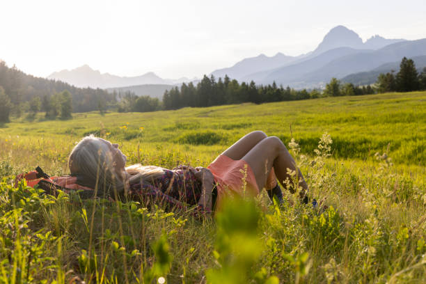 istock Senior female hiker relaxes in mountain meadow 1504243019