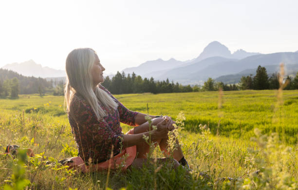 istock Senior female hiker relaxes in mountain meadow 1504243028