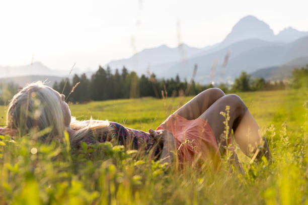 istock Senior female hiker relaxes in mountain meadow 1504243044