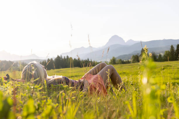 istock Senior female hiker relaxes in mountain meadow 1504243052
