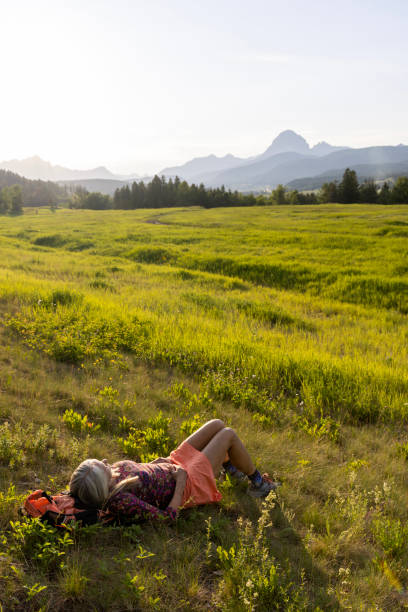 istock Senior female hiker relaxes in mountain meadow 1504244142