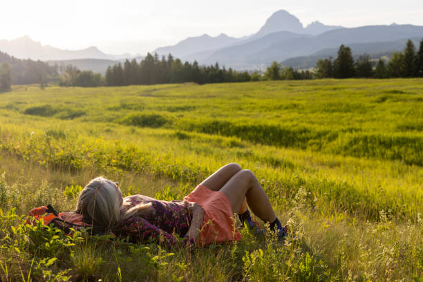 istock Senior female hiker relaxes in mountain meadow 1504244145