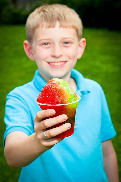 istock Young boy holds a snowcone out to the camera. 150424479