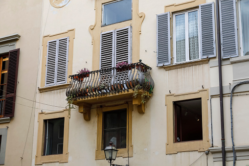 Balcony of townhouse in the old town. Several windows in this building are equipped with shutters.