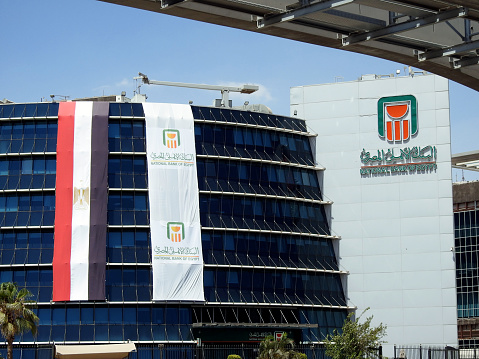 Cairo, Egypt, June 29 2023: Cairo Monorail columns and railway The National bank of Egypt Al Ahly Egyptian bank with the bank and Egyptian flags celebrating anniversary of the bank 125 years, selective focus