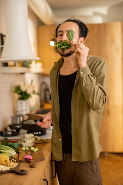 istock Man having fun while cooking healthy vegetarian food 1504283660