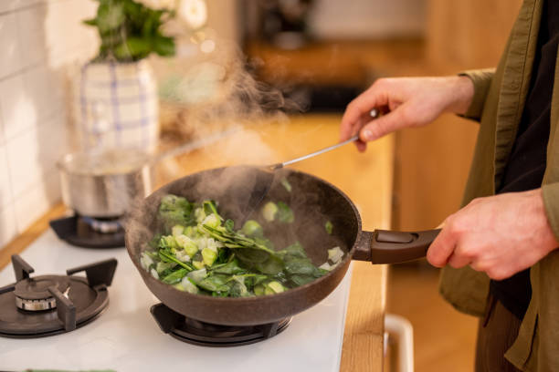 istock Man frying spinach leaves and brussels sprouts 1504284174