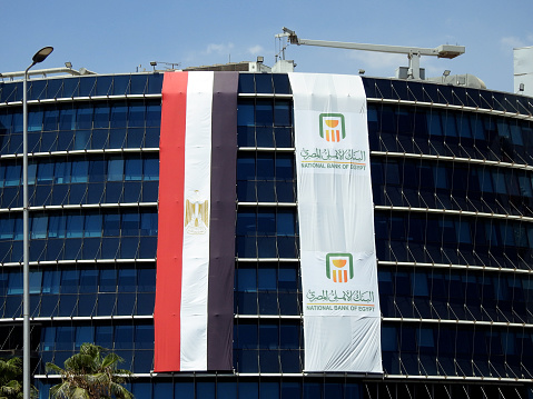 Cairo, Egypt, June 29 2023: The Exterior of the National bank of Egypt Al Ahly Egyptian bank with the bank flag and the Egyptian flag celebrating the anniversary of bank 125 years, selective focus