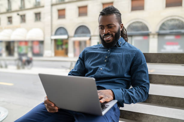 istock Dark-skinned man with a laptop working outside 1504300337