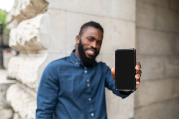 istock Bearded young dark-skinned man with a phone 1504300400
