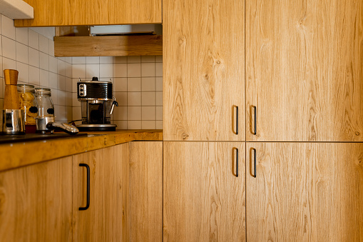 Close-up of kitchen facades made of oak veneer with black hadles